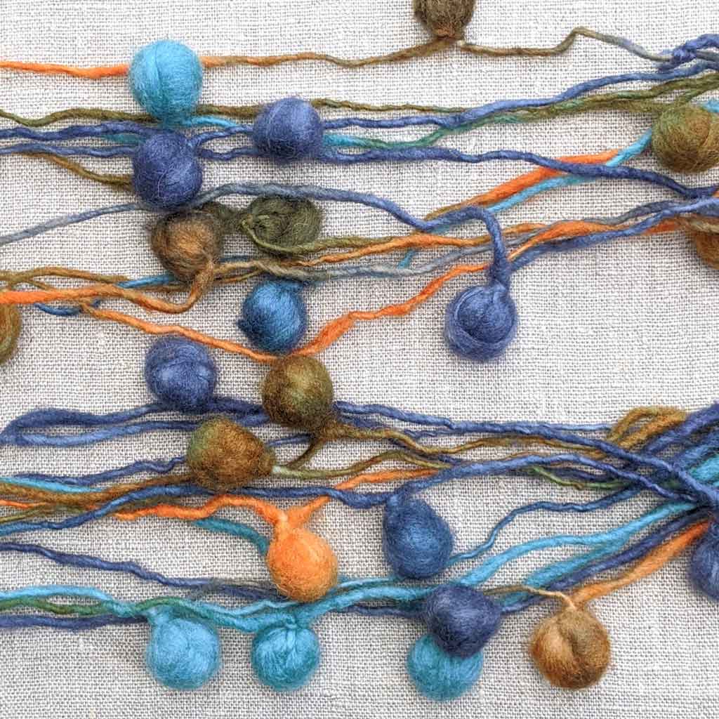 blue art yarn with pompoms